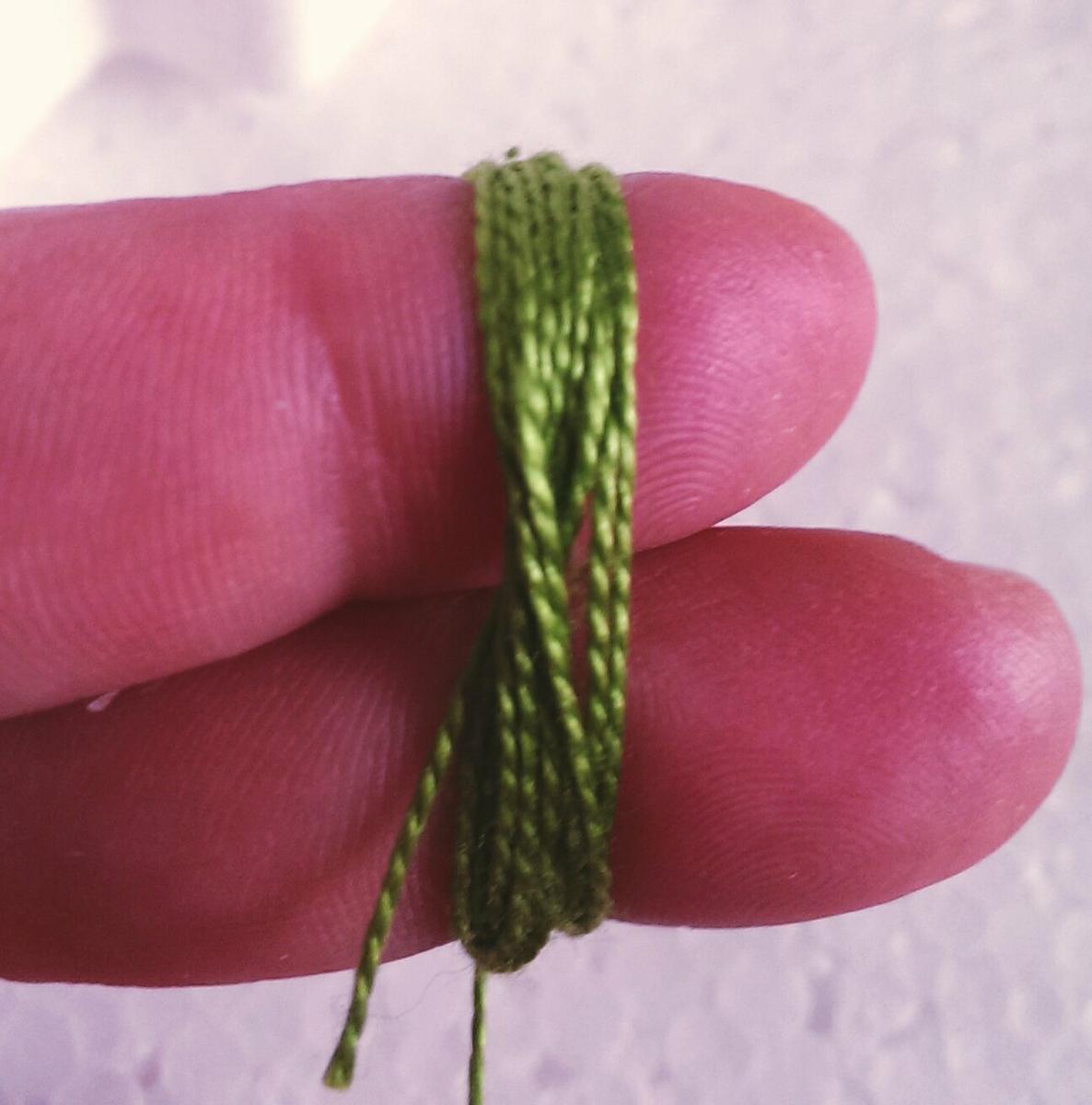 Usaremos un hilo de bordar y anudamos con nuestros dos dedos.