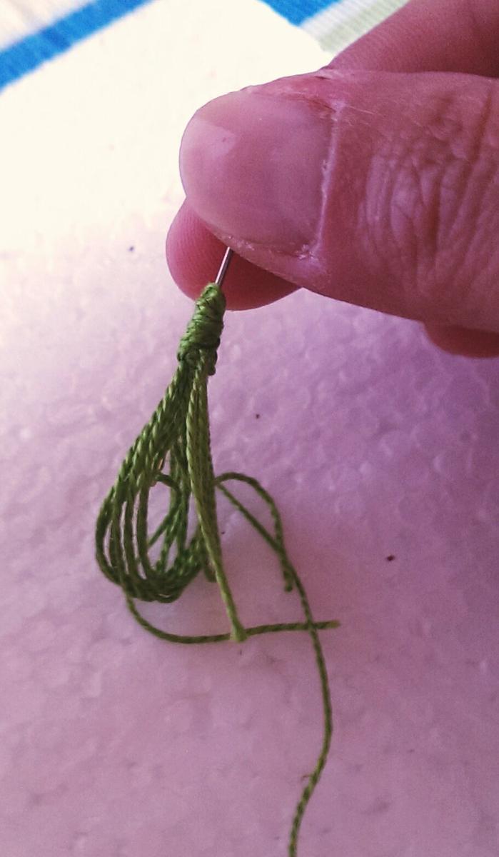 pasamos la aguja por el centro del extremo anudado