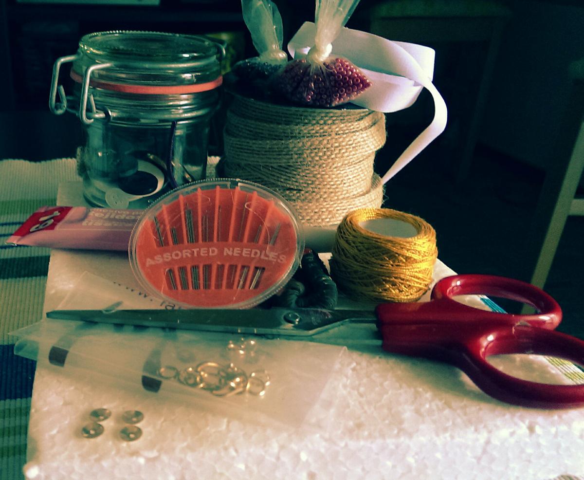 Agujas, cinta de rafia, botón, cuerda de color, hilo de bordar, aguja, pegamento de tijeras, lentejuelas , cuentas , anillas y cinta de marcar térmica.