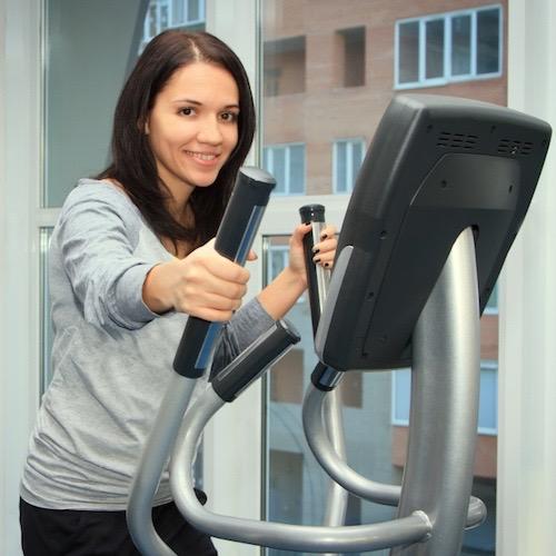 young woman doing exercise on a elliptical trainer