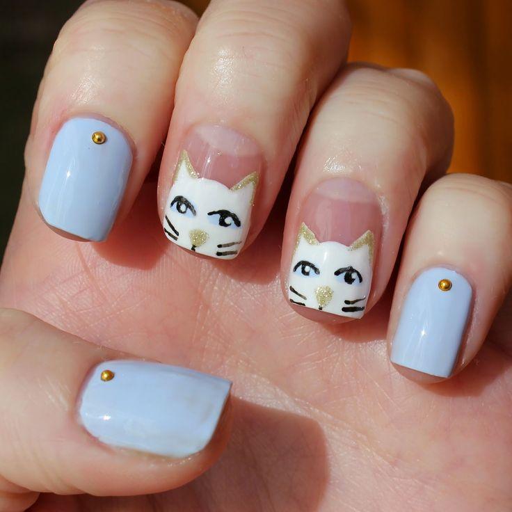 gato blanco en uñas azules