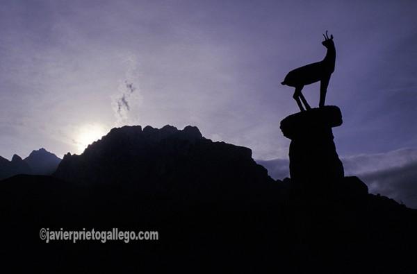 Vista del monumento al rebeco en el mirador de El Tombo, con los Picos de Europa al fondo. Valle de Valdeón. León. Castilla y León. España.