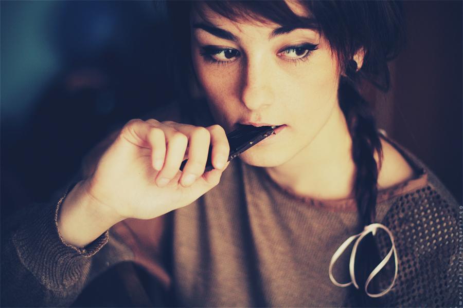 chica dando un bocado a un trozo de chocolate