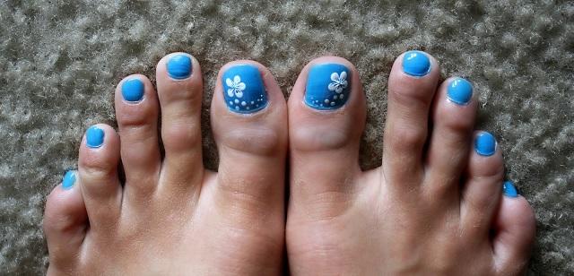 flores blancas con azul en uñas de los pies