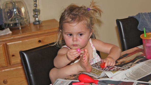 niña pintando uñas