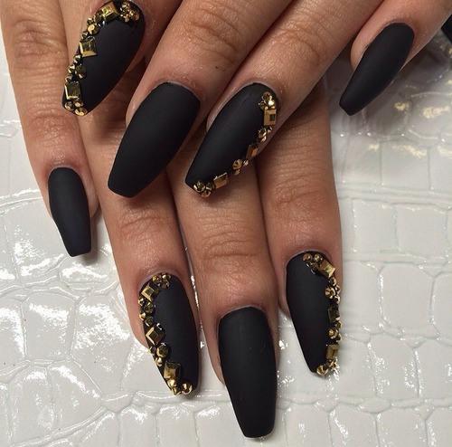 uñas largas con accesorios dorados
