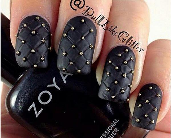 uñas negras con accesorios dorados