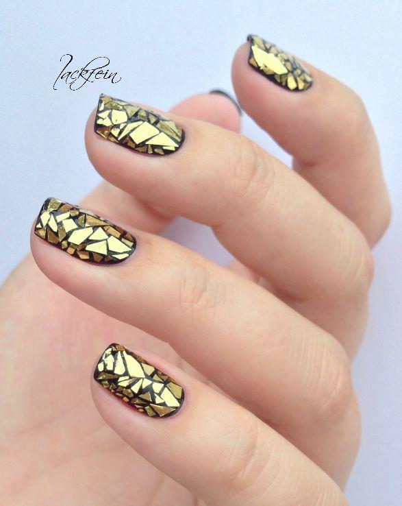 uñas negras y doradas con accesorios