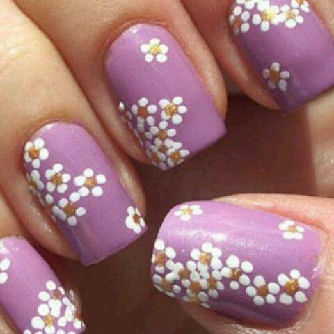 uñas moradas con pequeñas flores