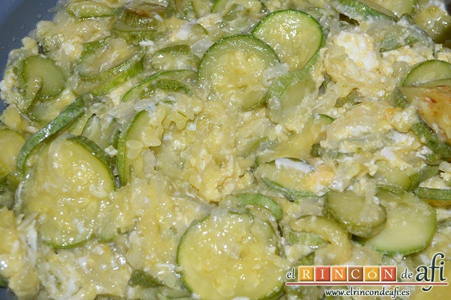 Zarangollo, con la ayuda de una cuchara de madera removemos con cuidado los huevos para que se mezclen con la cebolla y los calabacines