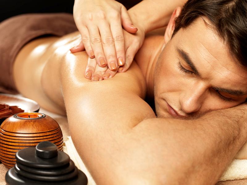 Masseur doing massage on man body in the spa salon. Beauty treatment concept.