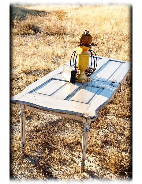 Mesa de jardín realizada con una puerta reciclada y una estructura de mesa