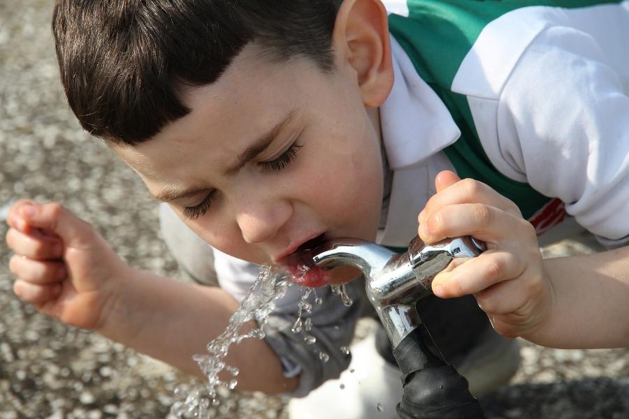 Boy Drinking Water From A Tap