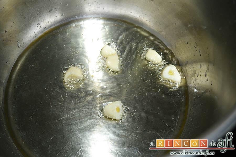 Pollo con salsa de almendras, dorar los ajos en una olla exprés con aceite de oliva