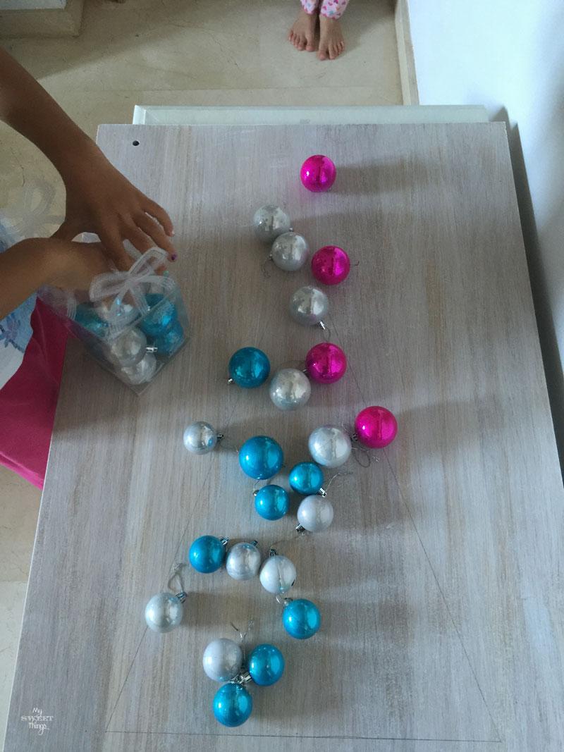 Con un trozo de madera y algunas bolas de Navidad podemos hacer un árbol de Navidad alternativo | DIY | Via www.sweethings.net