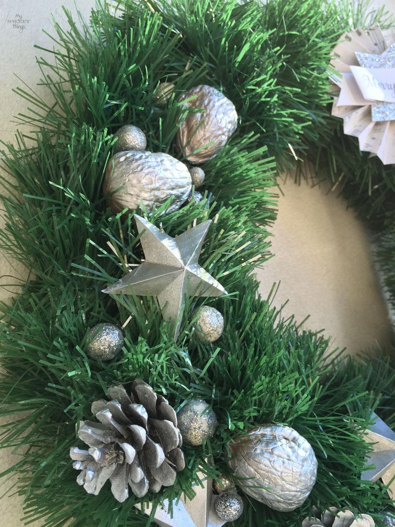 Cómo hacer una corona de Navidad casera fácil y elegante, usando cartón, piñas, nueces y una guirnalda | Via www.sweethings.net 