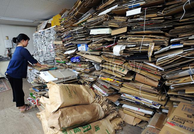 A resident disposes of cardboard boxes at the waste disposal site in central Kamikatsu Town in Shikoku, Japan. The town, whose residents number just over 2,000 people, has implemented a waste recycling policy that aims at eliminating waste entirely within the next 12 years and employs retired local residents to care for the waste disposal center. Waste must be divided up into 34 categories. Photographer: Robert Gilhooly