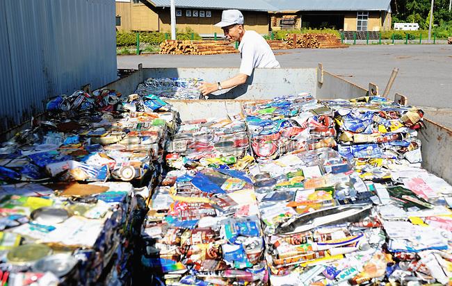 Masaru Goto, 73, stacks up crushed aluminum cans as part of his daily chores at the waste disposal site in central Kamikatsu Town in Shikoku, Japan on July 22, 2008. The town, whose residents number just over 2,000 people, has implemented a waste recycling policy that aims at eliminating waste entirely within the next 12 years and employs retired local residents to care for the waste disposal center. Photographer: Robert Gilhooly