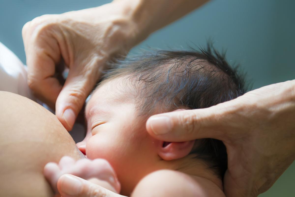 Enfermera ayuda a la lactancia materna de beb recin nacido colocndolo en el pecho de la madre