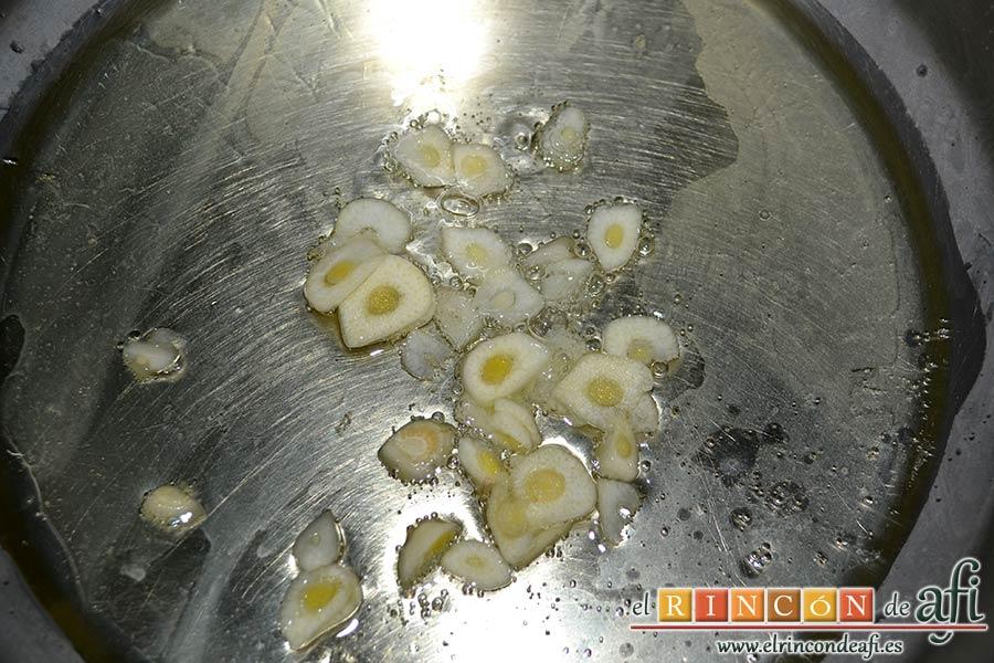 Sopa de almejas, en el mismo caldero ponemos aceite de oliva y los ajos laminados