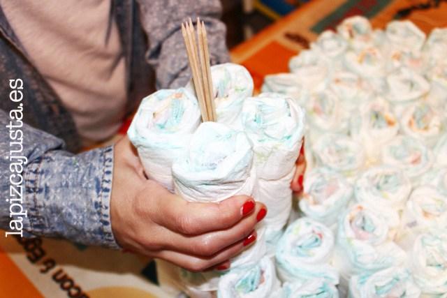 colocar los pañales sobre los palos para la torre del castillo de pañales