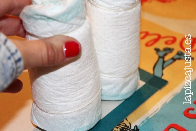 colocar uno a uno los pañales para formar la base del castillo