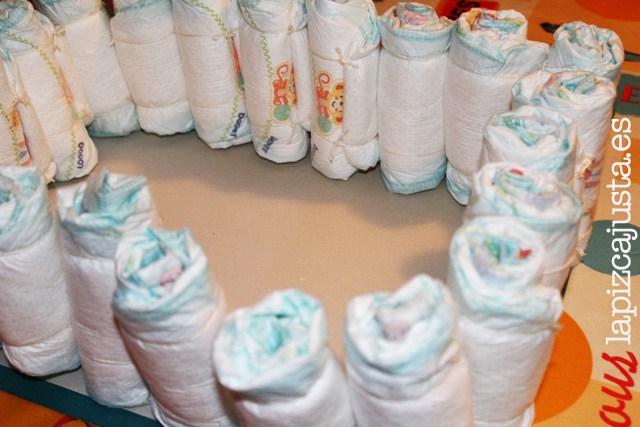 colocar uno a uno los pañales para formar la base del castillo