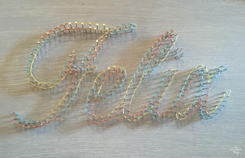 How to make an cool string wall art as a DIY birthday gift using a piece of scrap wood, some yarn and head nails