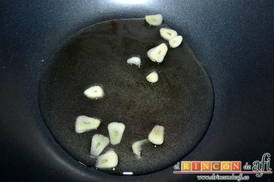 Gambones salteados con especias al wok, rehogar los ajos laminados en un wok con aceite de oliva bien caliente
