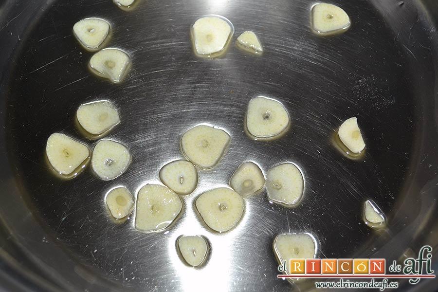 Solomillo de cerdo en salsa de naranjas y jengibre, laminar dos ajos y ponerlos con un poco de aceite en una cazuela