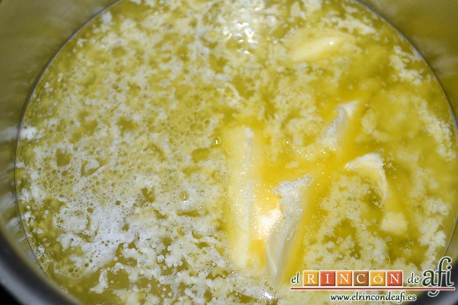 Profiteroles rellenos de nata (crema de leche) y cubiertos con chocolate, derretir la mantequilla