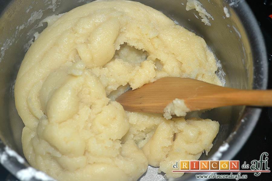 Profiteroles rellenos de nata (crema de leche) y cubiertos con chocolate, remover bien y con fuerza