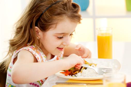 Little Girl Eating Vegetable Meal in a restaurant.