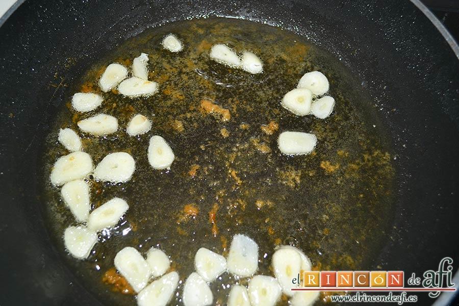 Bacalao a la tranca con pimientos asados, retirar una parte del aceite y dorar los ajos