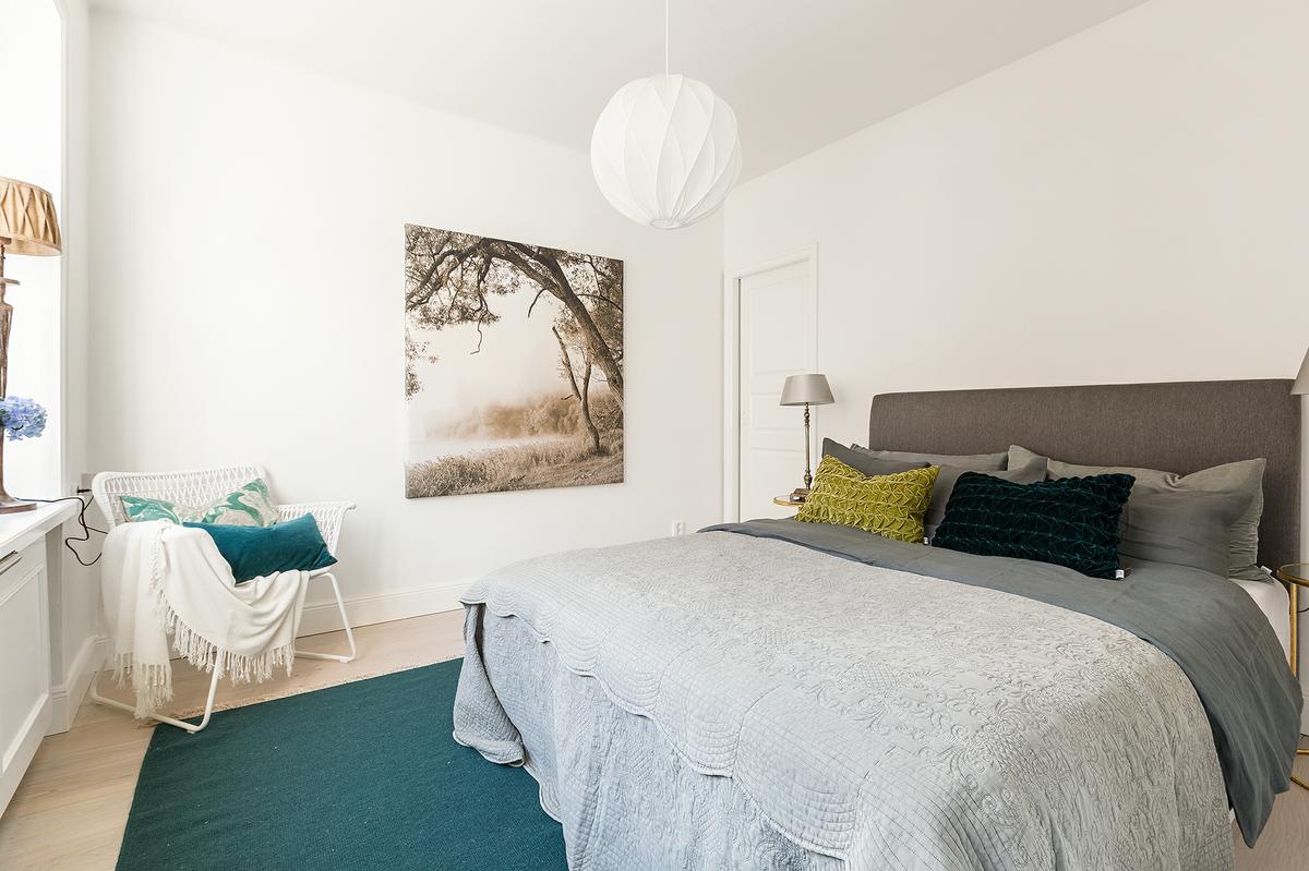 Vista del dormitorio decorado en tonos blancos de un piso pequeño