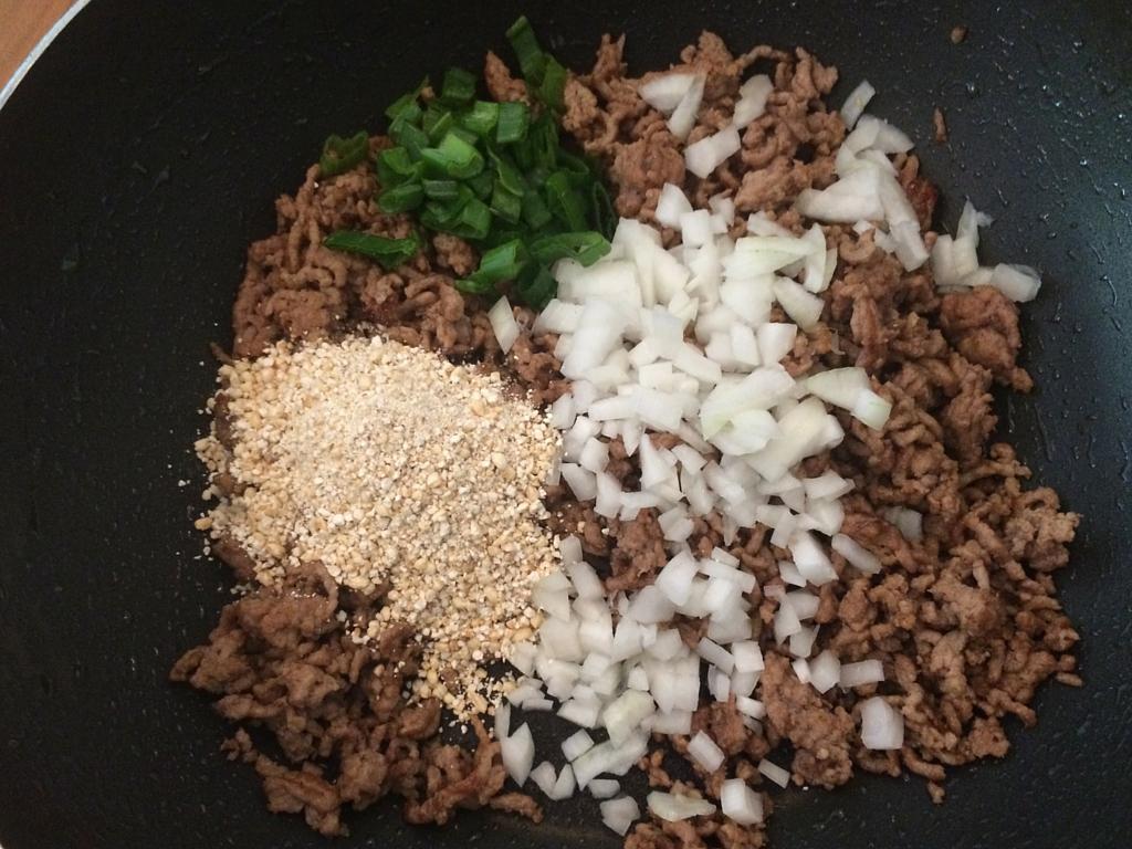 Añade el arroz tostado, la parte blanca y verde de la cebolleta.