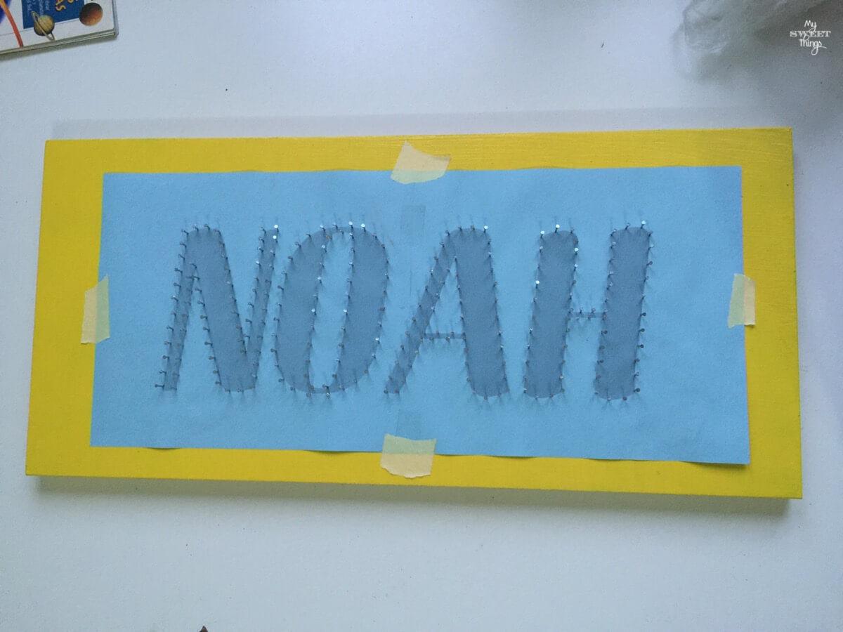 Un hilorama como regalo de cumpleaños usando un trozo de madera y puntillas