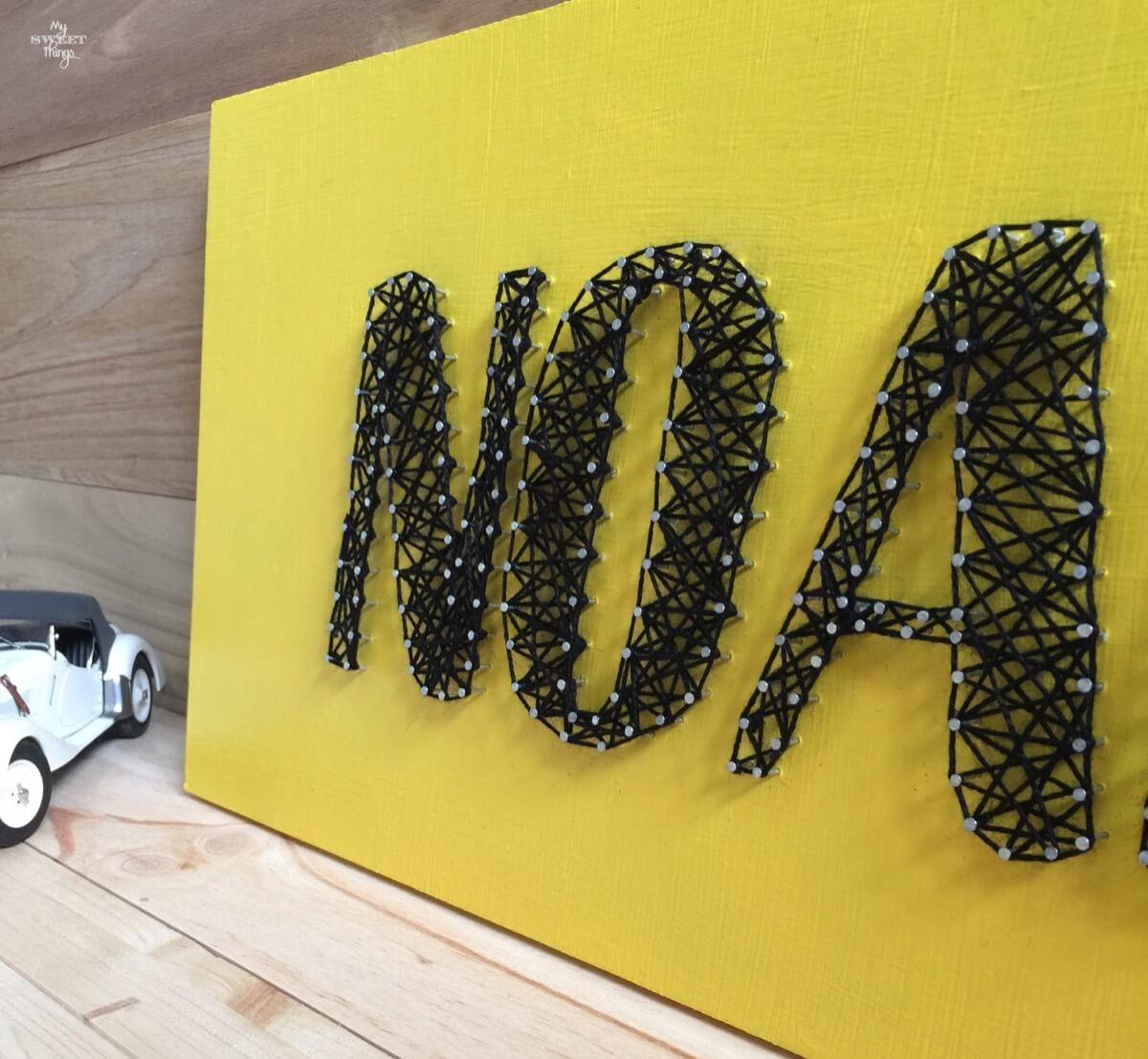 Un hilorama como regalo de cumpleaños usando un trozo de madera y puntillas