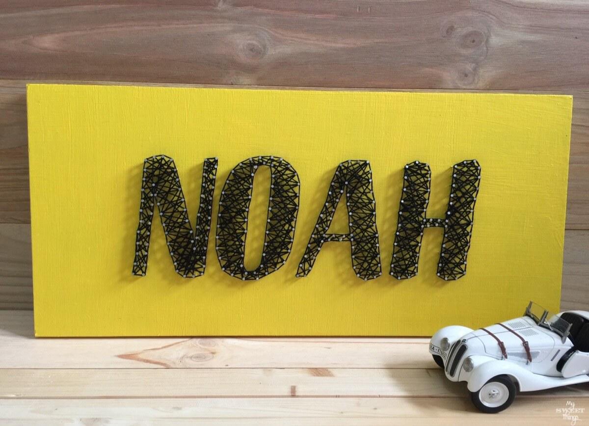 Un hilorama como regalo de cumpleaños usando un trozo de madera y puntillas