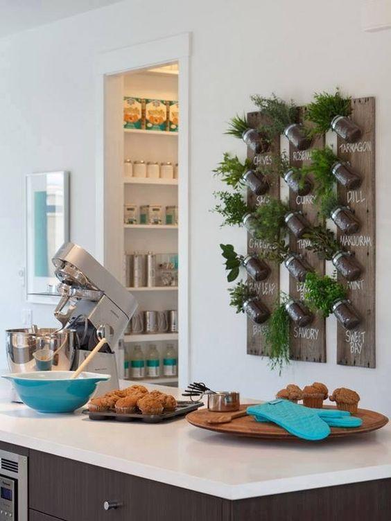Cocina decorada con una zona verde vertical con plantas aromáticas