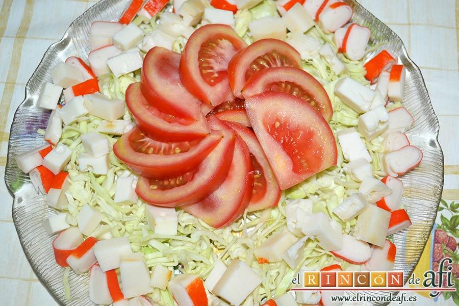 Ensalada con tomate, huevos, queso, col y palitos de cangrejo, colocar los tomates en gajos en el centro