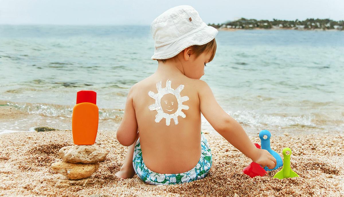 The sun drawing sunscreen on baby (boy) back.