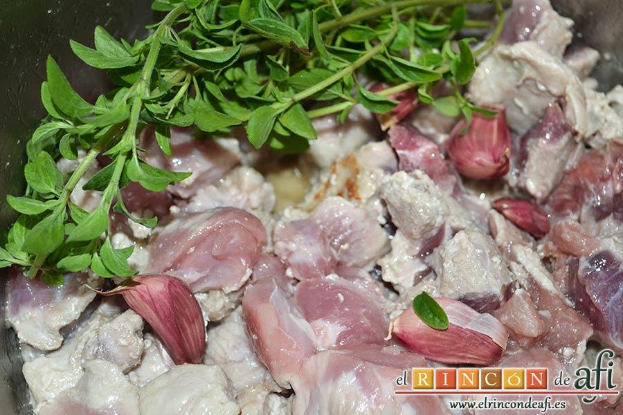 Estofado de cerdo, añadir los dientes de ajo y las ramitas de orégano fresco