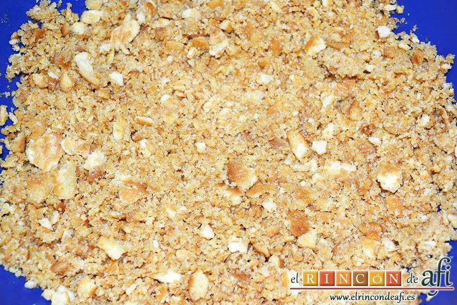 Tarta de quesos con mermelada de frutos rojos, triturar las galletas y los bizcochos mezclándolos con la mantequilla derretida