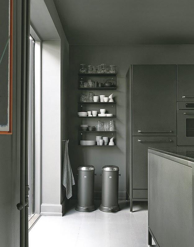 Los icónicos cubos de basura que lanzaron la firma Vipp al estrellato, descansan bajo una estantería con menaje también de Vipp.