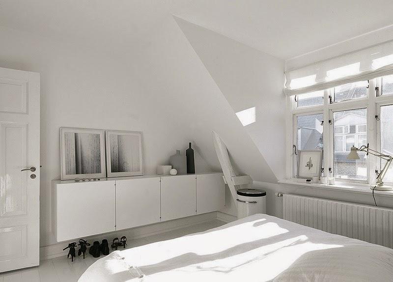 En la habitación principal, un contenedor alargado de PO Inventar funciona como cómoda. La cama es de Hästens y la lámpara de Fontana Arte. Hasta las fotografías de Anders Hviid juegan al binomio blanco y toque negro.