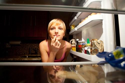 mujer mirando que hay dentro del refrigerador