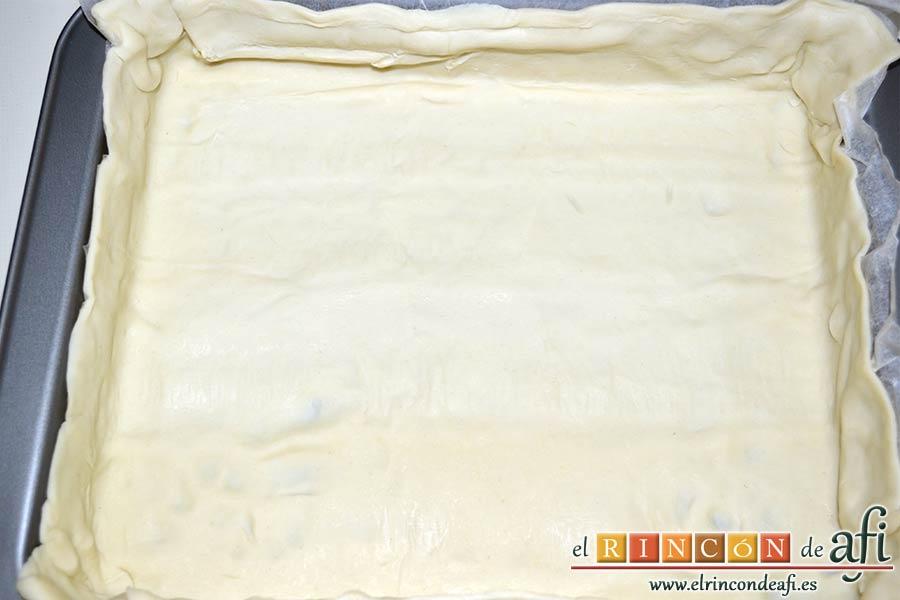 Hojaldre relleno con crema pastelera y manzana, acoplar la masa de hojaldre al molde usando el papel