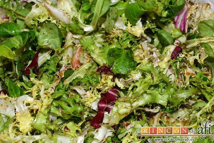 Costillas crujientes de cerdo en leche, verter el aliño sobre el mezclum de lechugas