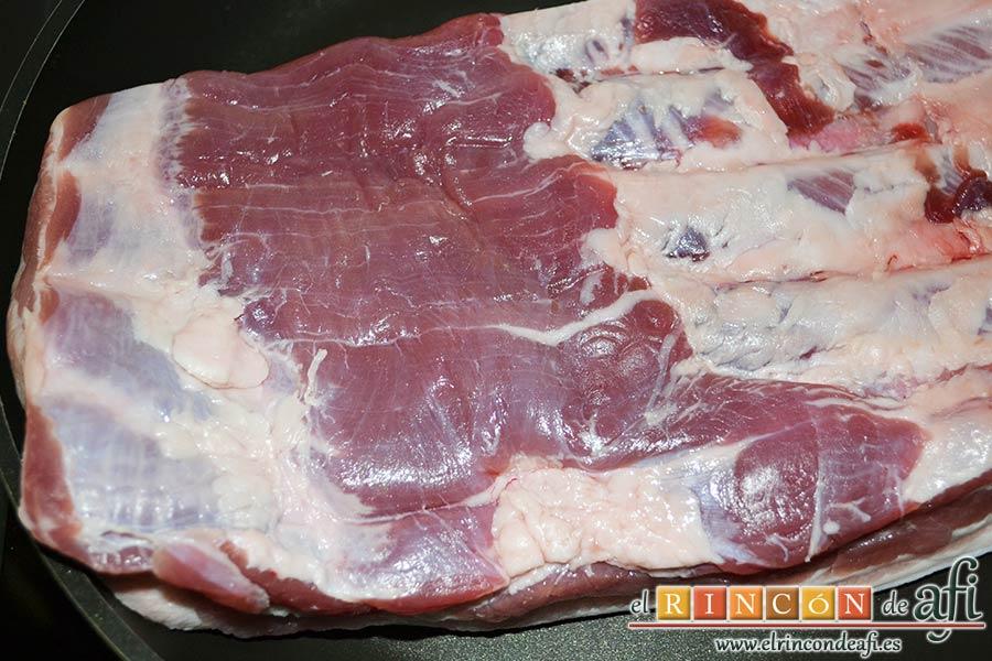 Costillas crujientes de cerdo en leche, ponemos el costillar sobre una sartén bien caliente con la piel hacia abajo para que se nos dore